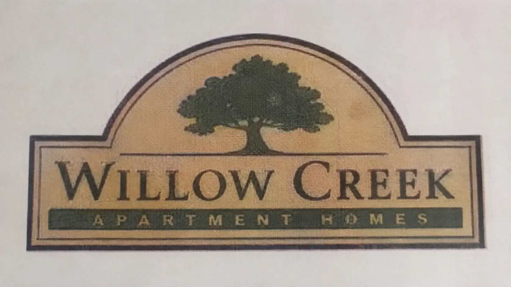 Scanned monument-sign logo with JPEG artifacts and faded edges